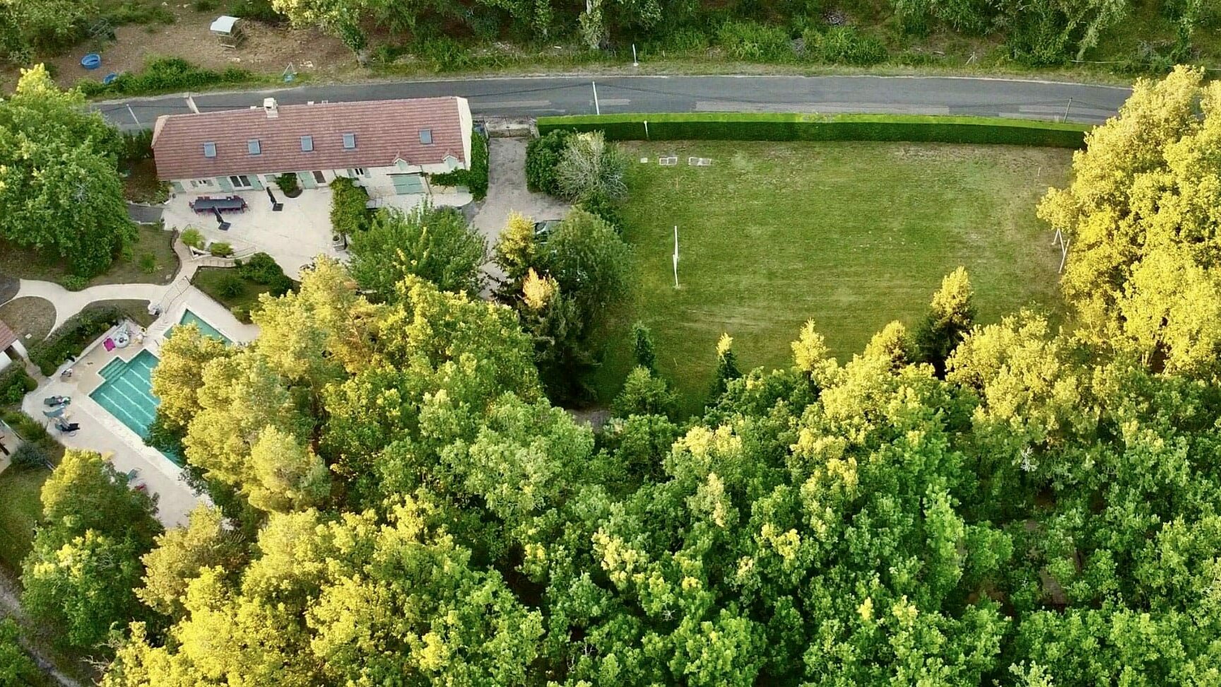 Vue aérienne du terrain du grand gîte avec la piscine, la longère et le terrain de rugby disponibles avec la location