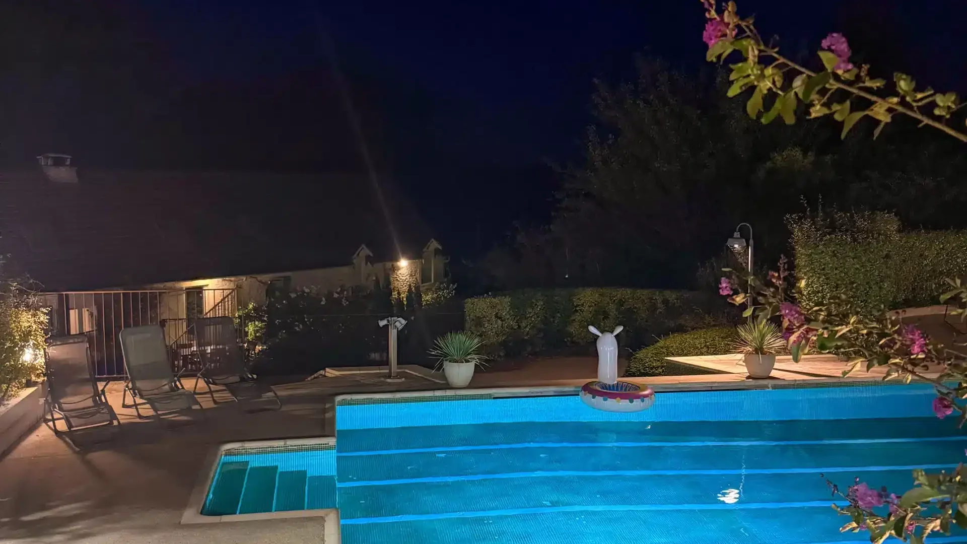 Grande piscine vue de nuit avec les transats et éclairage autour et dans la piscine du gîte pour 15 personnes du Clos des Aubiers