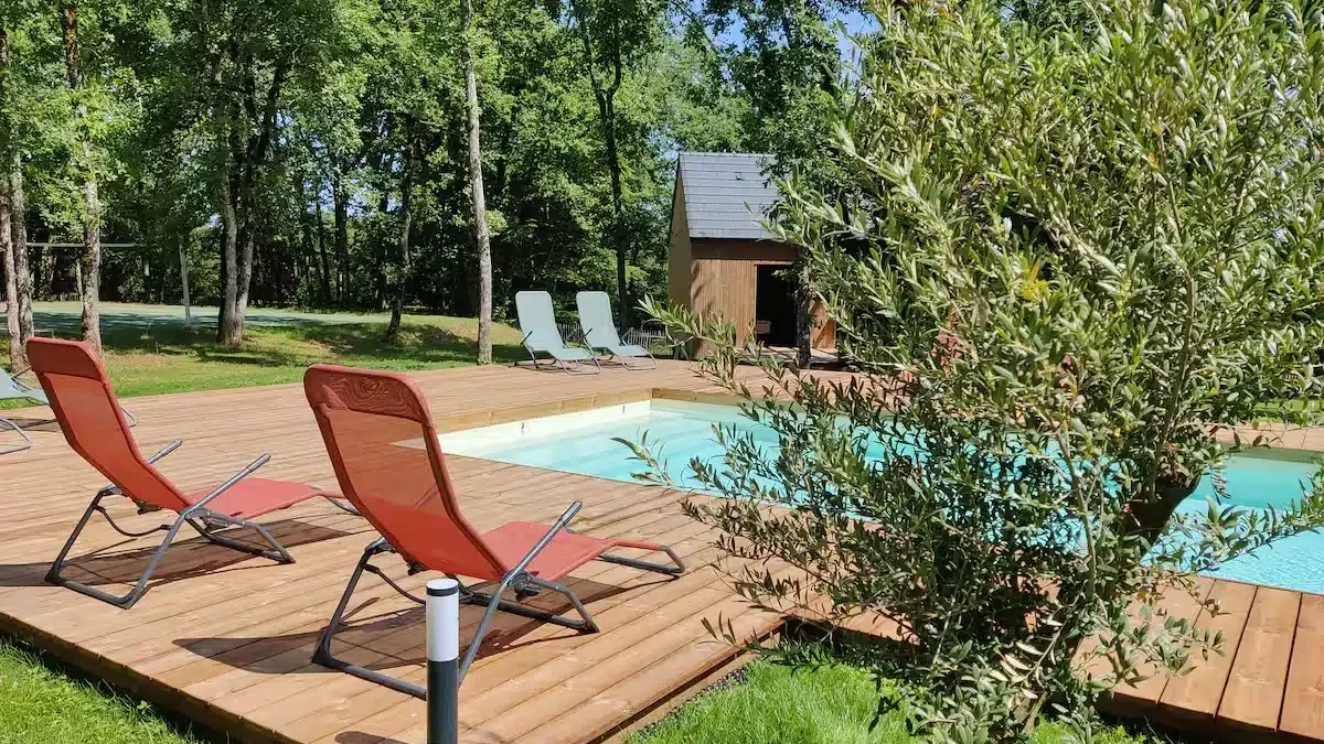 Piscine chauffée du gîte la Clairière des Aubiers avec terrasse et transats