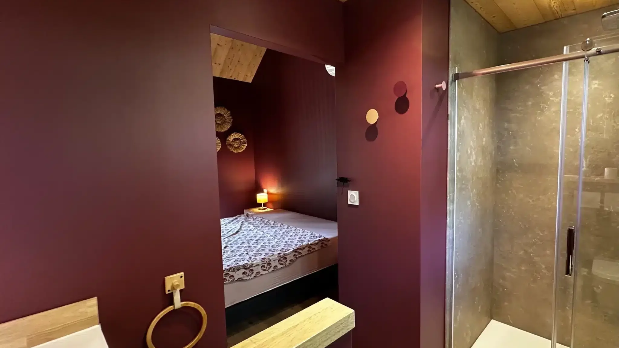 Douche italienne avec vue sur la chambre rouge bordeaux du gîte la Clairière des Aubiers